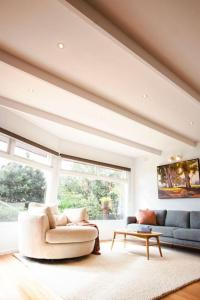 a living room with a couch and a table at Very Cool Mid Century, Pet Friendly Urban Oasis in Geelong