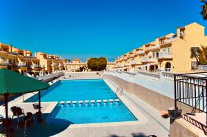 a swimming pool in front of some buildings at Refugio de Tranquilidad en Gran Alacant in Gran Alacant