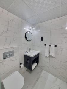 een witte badkamer met een wastafel en een toilet bij Kusadasi Sezgins Boutique Rooms in Kuşadası