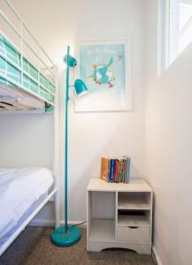 Very Cool Mid Century, Pet Friendly Urban Oasis في جيلونج: غرفة نوم مع مصباح في الطابق الأزرق بجوار سرير