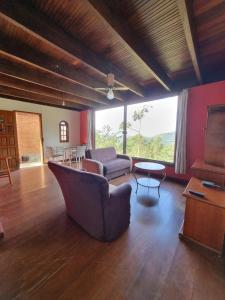 uma sala de estar com um sofá e uma mesa em Chalés Pico do Caledônia em Nova Friburgo