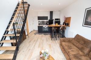 a living room with a staircase and a kitchen at Duplex tout confort - Gare TGV et hypercentre par Groom* in Lorient