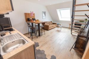 a kitchen with a sink and a living room at Duplex tout confort - Gare TGV et hypercentre par Groom* in Lorient