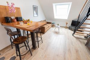 een woonkamer met een houten tafel en een bank bij Duplex tout confort - Gare TGV et hypercentre par Groom* in Lorient