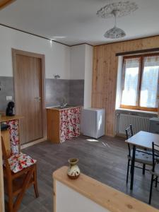 a room with a kitchen and a table and chairs at B&B La Mëisun in Perrero +10 photos