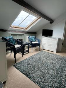 a living room with two chairs and a skylight at Rosegarth Guest House in Ravenglass