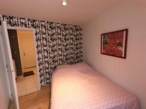 a small bedroom with a bed and a curtain at Appartement T2 45m² avec terrasse - 4/6 personnes in Le Mont-Dore