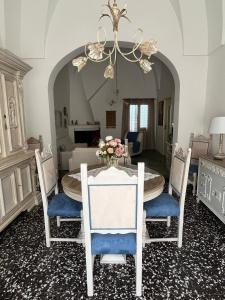 un comedor con una mesa con sillas y una lámpara de araña en La casa del nonno, en Borgagne