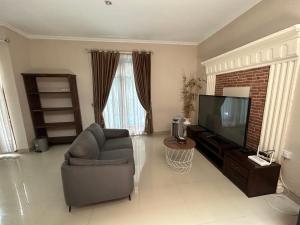 - un salon avec un canapé et une télévision dans l'établissement Guest House DiFi Timoho, à Demangan
