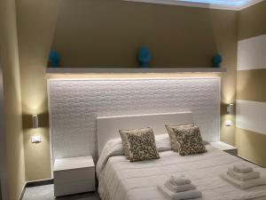a bedroom with a white bed with two pillows at B&B Palazzo Diaz in Marsala