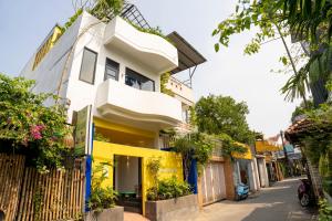 een wit en geel huis in een straat bij BÁNH INN in Hue