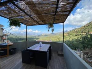 un tavolo su un balcone con vista sulle montagne di Maison de caractère, Zilia, au pied du Montegrossu a Zilia