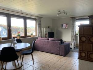 a living room with a purple couch and a table at de Vinkenborg nabij Winterberg in Winterberg
