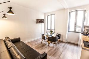 een woonkamer met een bank en een tafel bij Belle rénovation moderne au coeur du Panier in Marseille