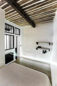 1 dormitorio con paredes blancas y techo de madera en Belle rénovation moderne au coeur du Panier en Marsella
