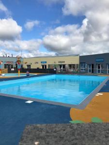 a large swimming pool in front of a building at Lizard ,Mullion holiday caravan in Mullion