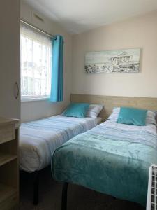 two beds sitting next to each other in a room at Lizard ,Mullion holiday caravan in Mullion