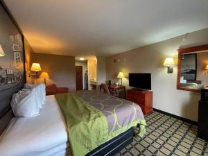 a hotel room with a bed and a flat screen tv at Super 8 by Wyndham Rolla in Rolla