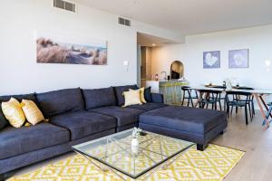 uma sala de estar com um sofá e uma mesa em Luxury Beach Front Apartment Moana - Waterviews em Moana