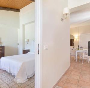 1 dormitorio con 1 cama blanca y cocina en B&B VillaSalento LE, en Cavallino di Lecce
