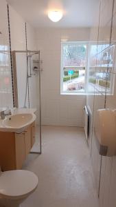a bathroom with two sinks and a shower and a window at Vandrarhem i Ullared in Ullared