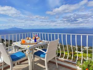a table and chairs on a balcony with the ocean at B&B Il Bacio di Capri in Anacapri