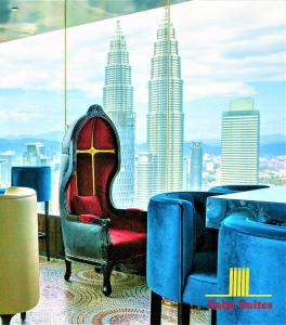 a chair in a room with a view of the city at Saba Suites at Platinum KLCC Bukit Bintang Kuala Lumpur in Kuala Lumpur