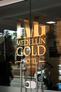 um sinal na janela de um hotel de ouro em hotel medellin gold em Medellín