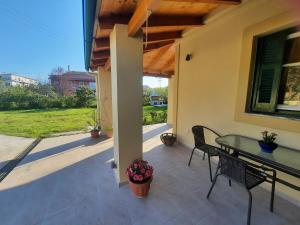 un patio con tavolo e sedie su una casa di Corfu River House a Potamós