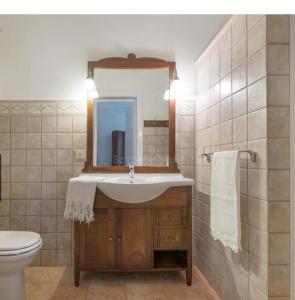 y baño con lavabo, espejo y aseo. en B&B VillaSalento LE, en Cavallino di Lecce