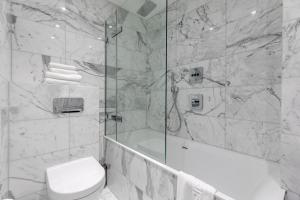 a bathroom with a tub and a toilet and a shower at StayInn Aldgate in London