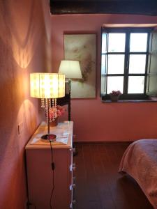 a bedroom with a lamp on a dresser next to a bed at Villa Belvedere in Pieve Fosciana
