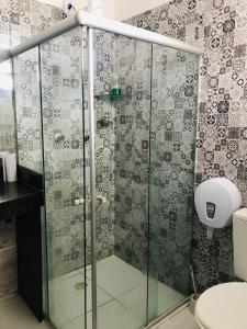 a bathroom with a glass shower with a toilet at Pousada Cantinho do Sossego in Petrolina