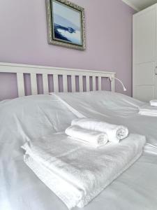 a white bed with two towels on it at Leut in Nečujam