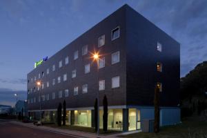 um edifício preto com uma luz de rua em frente em Holiday Inn Express Pamplona, an IHG Hotel em Mutilva Baja