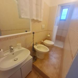 a white bathroom with a sink and a toilet at Aria di sale in Trapani +23 photos