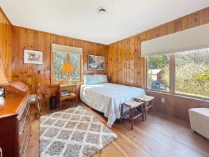 Cape NeddickSeacoast Sanctuary的一间带床的卧室，位于一间带木墙的房间里