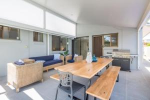 uma sala de estar com uma mesa e um sofá azul em Mooloolaba Escape to Mooloolaba & Feel At Home in Style em Mooloolaba