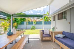 a patio with a blue couch and a table at Mooloolaba Escape to Mooloolaba & Feel At Home in Style in Mooloolaba