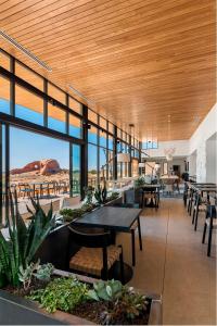 uma sala de jantar com mesas, cadeiras e janelas em ULUM Moab em La Sal