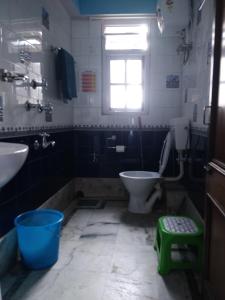 a bathroom with a toilet and a sink and a window at Divine Bliss Homestay in Darjeeling