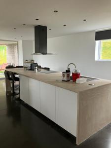 a kitchen with a long counter in a room at Le beau petit bosquet in Hotton