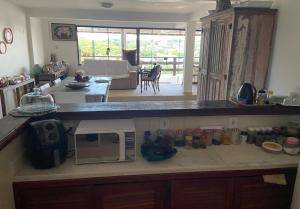 a kitchen with a counter top with a microwave at Suites Buzios in Búzios