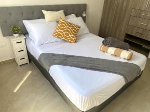 duże łóżko z białą pościelą i poduszkami w obiekcie Casa familiar cerca de la playa con terraza privada w mieście Cancún +24 zdjęcia