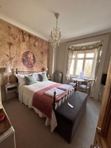 Un dormitorio con una cama grande y una lámpara de araña. en Hazel Manor en Harrogate
