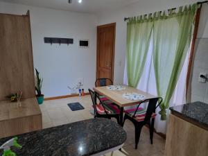 uma mesa e cadeiras num quarto com uma cozinha em Hermoso Monoambiente Céntrico em San Martín de los Andes