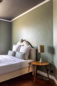 - une chambre avec un lit et une table avec une lampe dans l'établissement CHARME ZEN Thermes 3 Étoiles, à Chamalières