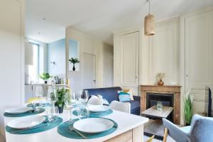 a dining room with a table and a fireplace at Appartement Le Somptueux - Idéalement Situé in Caluire-et-Cuire