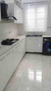 - une cuisine blanche avec cuisinière et évier dans l'établissement Jilles apartments -4bedroomduplex24hrlight&security, à Lekki