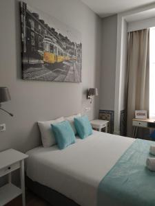 a bedroom with a bed and a picture of a train at Great Stay Fanqueiros Guest House 3 in Lisbon